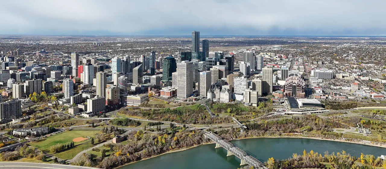 Wide aerial view of Edmonton with the downtown towers, the winding North Saskatchewan River and neighbourhoods stretching to the horizon
