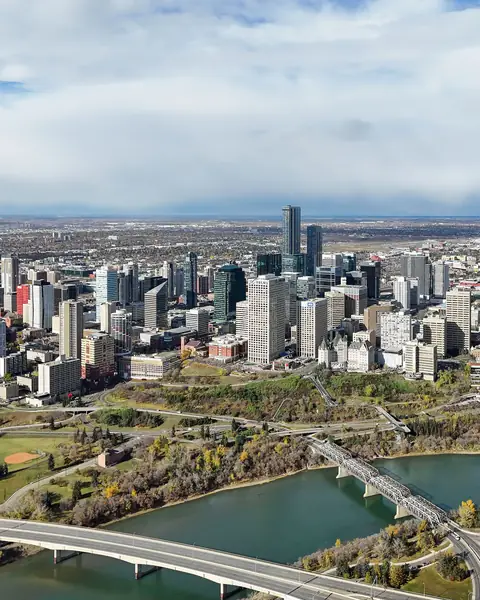 Wide aerial view of Edmonton with the downtown towers, the winding North Saskatchewan River and neighbourhoods stretching to the horizon