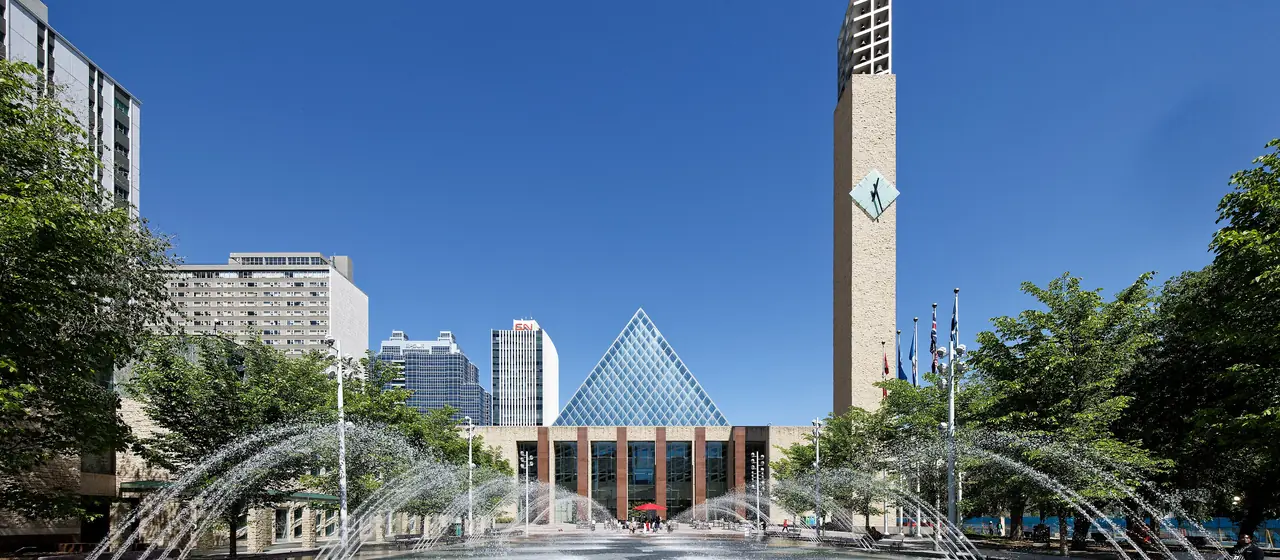 Edmonton City Hall's glass pyramid and clock tower behind the fountains of Sir Winston Churchill Square