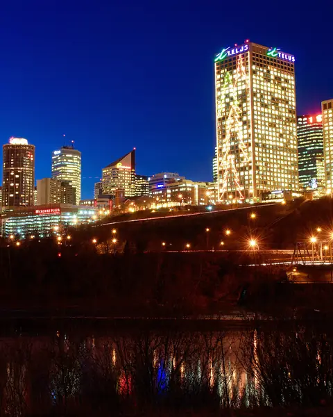 Downtown Edmonton's lit-up skyline at night, seen from across the river on the south side